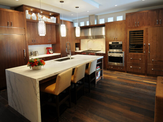 modern kitchen interior with walnut cabinets and white marble waterfall island countertop