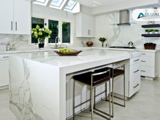 modern kitchen with large marble waterfall island white cabinets bar seating and marble backsplash