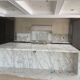 luxury kitchen with large marble waterfall island countertop and full slab stone design in modern interior