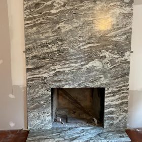 floor to ceiling marble fireplace surround with natural stone slab in modern living room interior