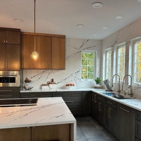 modern kitchen with calacatta quartz countertops full height backsplash and wood cabinetry in contemporary home interior