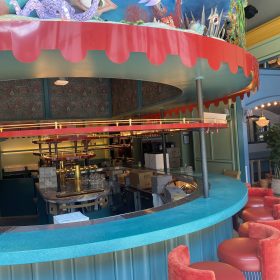 custom curved restaurant bar counter with colorful stone surface and decorative interior design