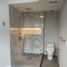 modern bathroom with calacatta marble walk in shower wall panels and illuminated shower niche design