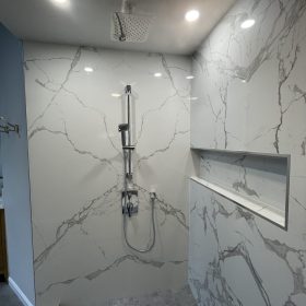 modern walk in shower with calacatta marble wall panels and built in shower niche design