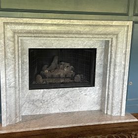 classic marble fireplace surround with carved stone mantel and traditional living room design