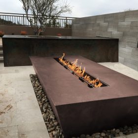 modern outdoor linear fire pit with stone patio and contemporary landscape design