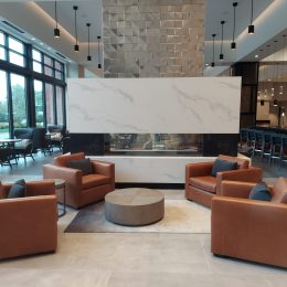 modern lobby lounge with marble fireplace wall, contemporary seating and luxury interior design
