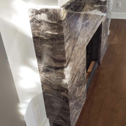 natural stone fireplace surround with dramatic veining modern marble slab installation in living room interior