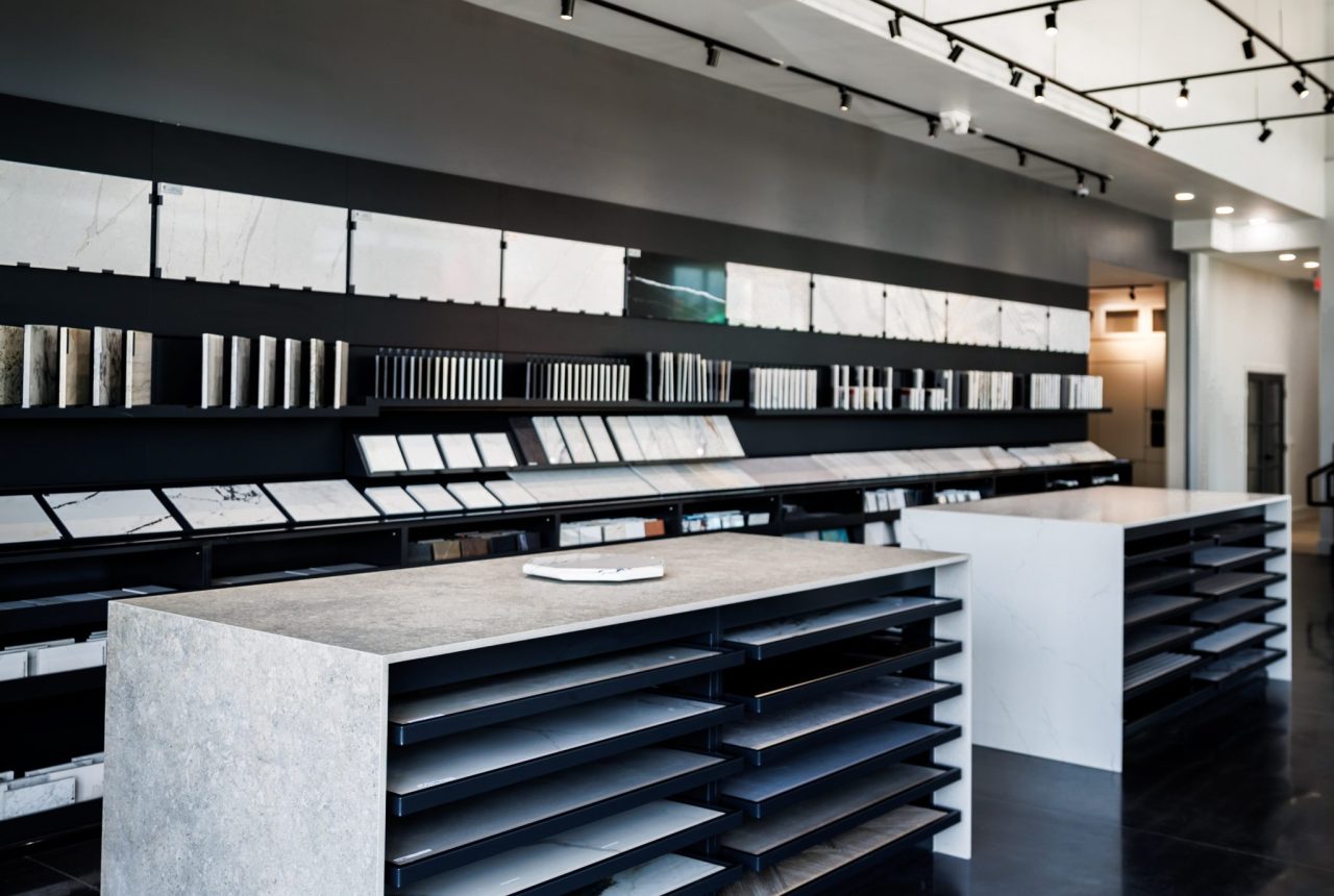 stone countertop sample display tables and quartz slab selection wall inside Richstone Surfaces design showroom