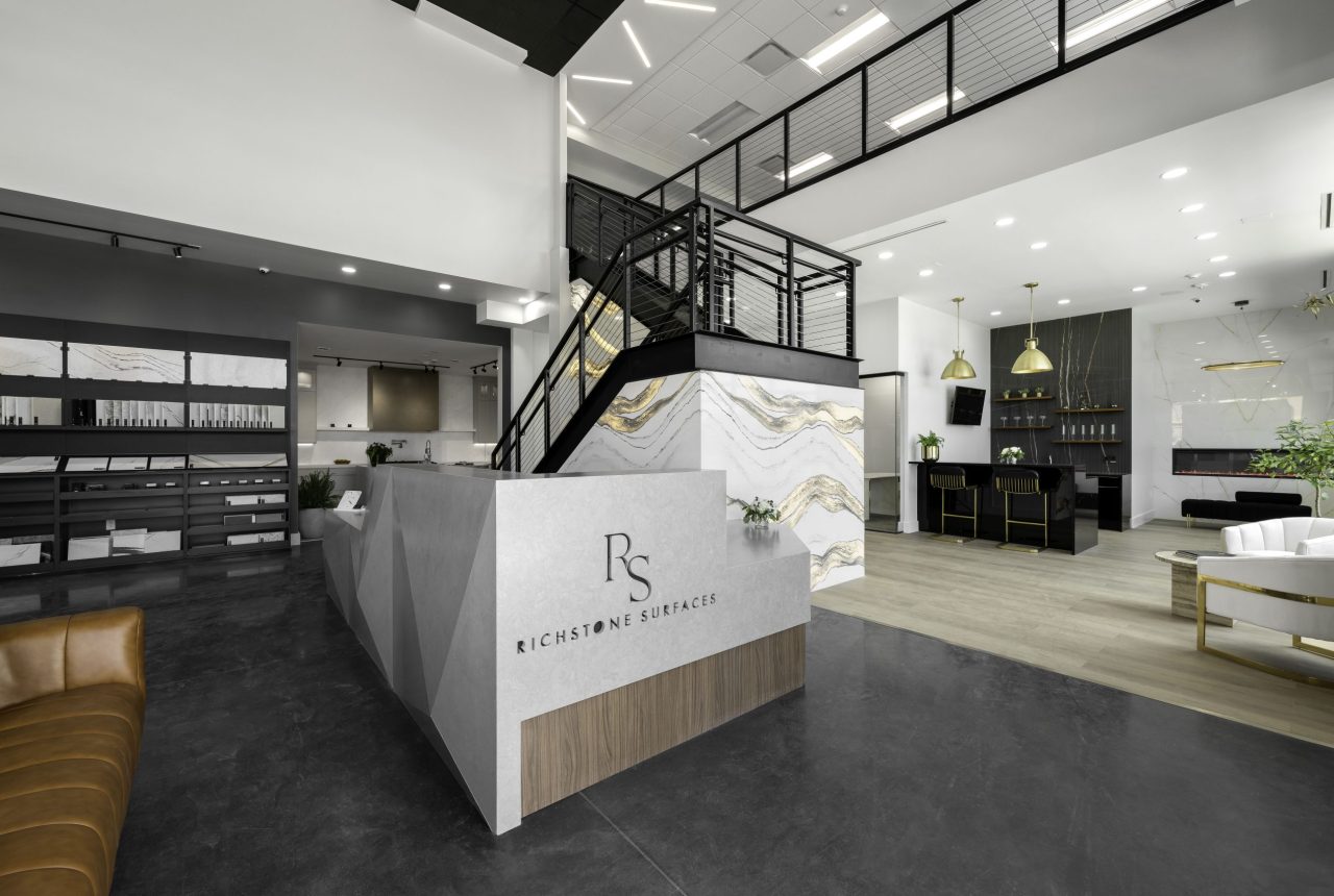 Richstone Surfaces design studio reception area with modern stone feature wall, staircase, and luxury countertop showroom displays